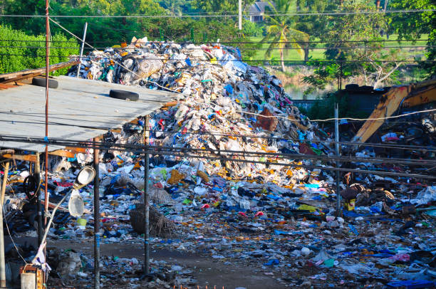Heavy machinery shredding garbage in an open air landfill. Waste