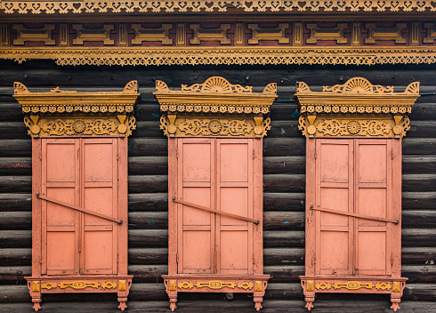 A window with wooden carved sashes. Wooden architecture