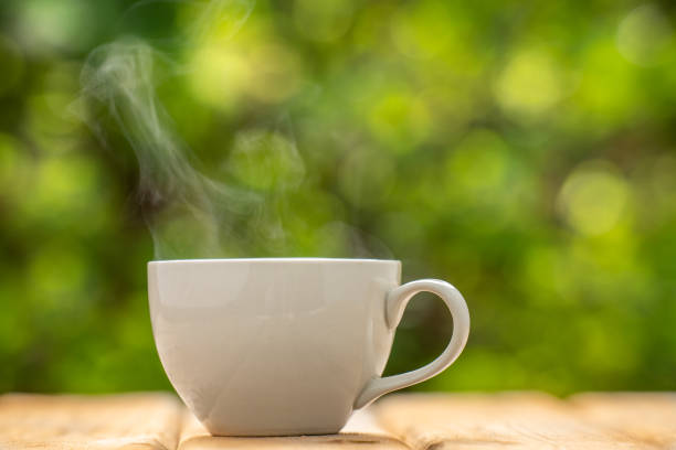 istock white ceramic coffee mug On the wooden floor, green tree bokeh background. soft focus.shallow focus effect. 1399743349