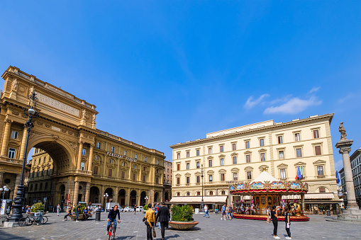 Tourists strolling in Piazza della Repubblica in Firenze, one of the oldest and most important squares of the city
