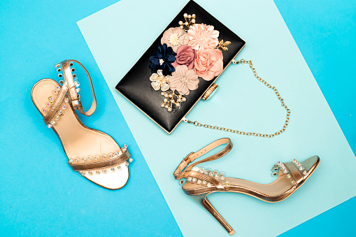 beautiful women floral black clutch, wedding bag and gold heel