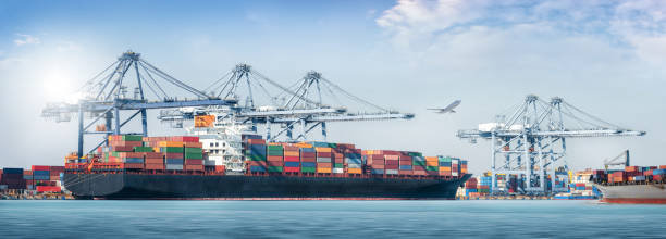 istock Panorama of Container cargo freight ship during discharging at industrial port move to container yard by trucks, handlers, cargo plane, logistic import export background and transport industry concept 1399746333