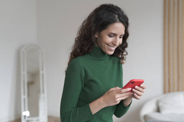 istock Young happy Spanish woman using mobile phone and chatting with friends, texting sms on smartphone 1399750334