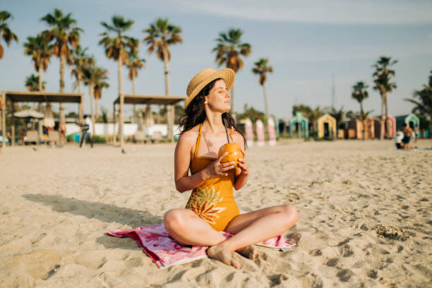 istock Woman with coconut drink relaxing at the beach 1399752351