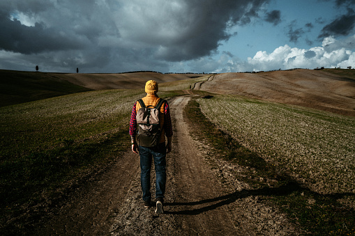 Walking in fields of Val d'Orcia at sunset. Italy, Tuscany