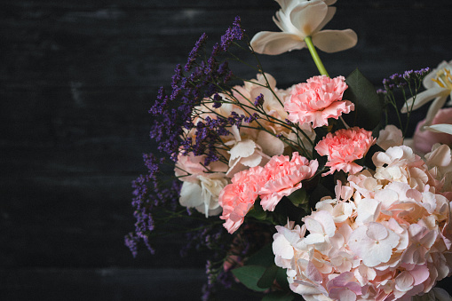 Beautiful bouquet of flowers against wooden background. Vintage styled.