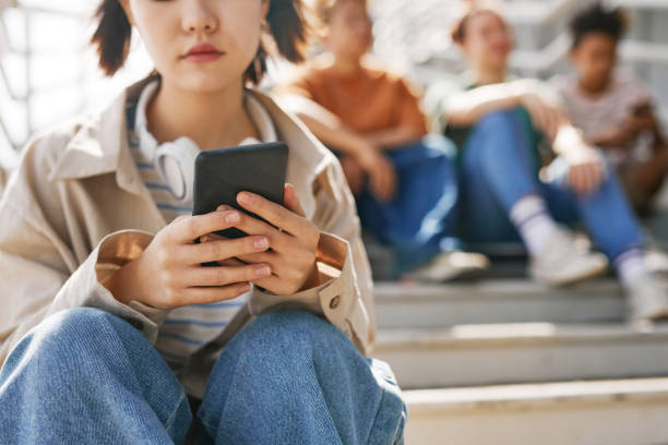 adolescente esperando mensaje de texto - exclusion fotografías e imágenes de stock