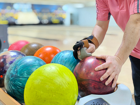 An Asian woman is practicing bowling preparing for upcoming tournament.
