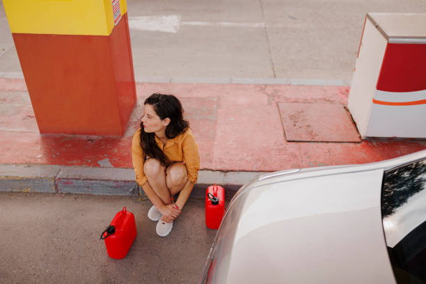 zdenerwowana kobieta z puszką po gazie na stacji benzynowej - gas station service red yellow zdjęcia i obrazy z banku zdjęć