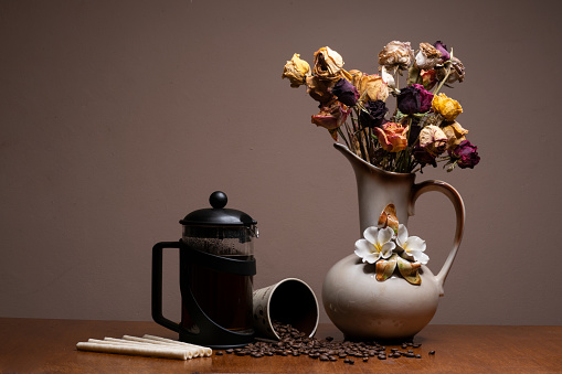 Black Filter coffee pot with a mug and coffee beans spilling out of it beautifully isolated on a plain background