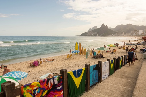 Ipanema Beach, Rio de Janeiro, Brazil. May 25, 2022: Bathers enjoying the sunny day. Two Brothers Hill in the background.