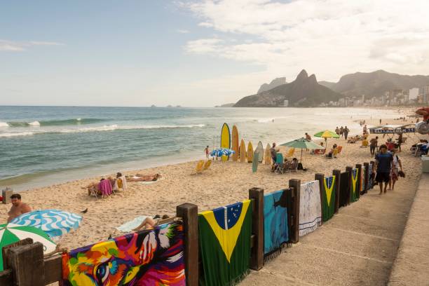 Ipanema Beach and Two Brothers Hill. Rio de Janeiro, Brazil. Ipanema Beach, Rio de Janeiro, Brazil. May 25, 2022: Bathers enjoying the sunny day. Two Brothers Hill in the background. two brothers mountain stock pictures, royalty-free photos & images