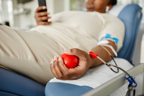Black Young Woman Donating Blood Closeup Close up of young black woman squeezing stress ball while giving blood at donation center, copy space organ donation stock pictures, royalty-free photos & images