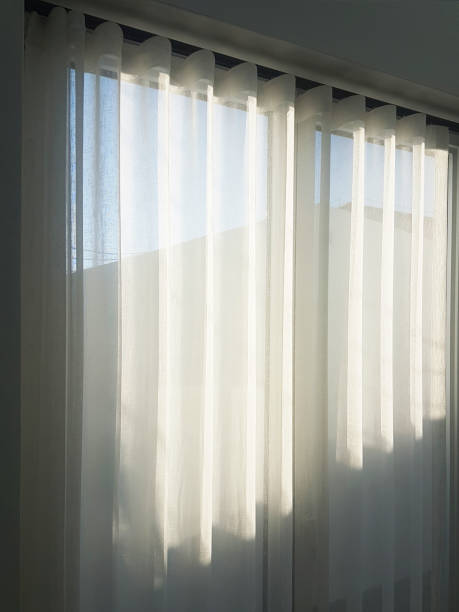 Transparent tulle with morning sun rays on shadow background