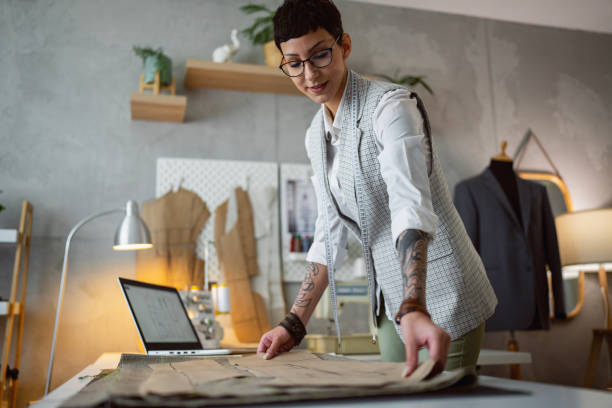 istock Caucasian female tailor and fashion designer preparing pattern, while working at her design studio 1399756585