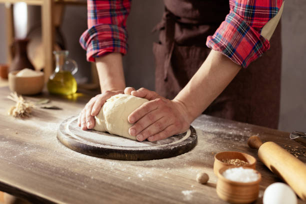 istock Baker man making dough and bakery ingredients for homemade bread cooking at table 1399756611