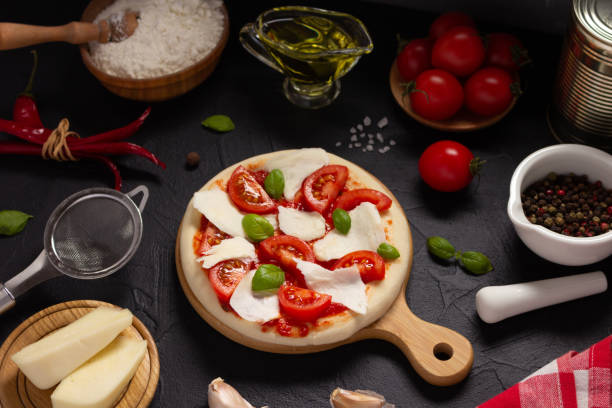 istock Italian pizza with ingredients on table. Pizza cooking at tabletop background 1399756640