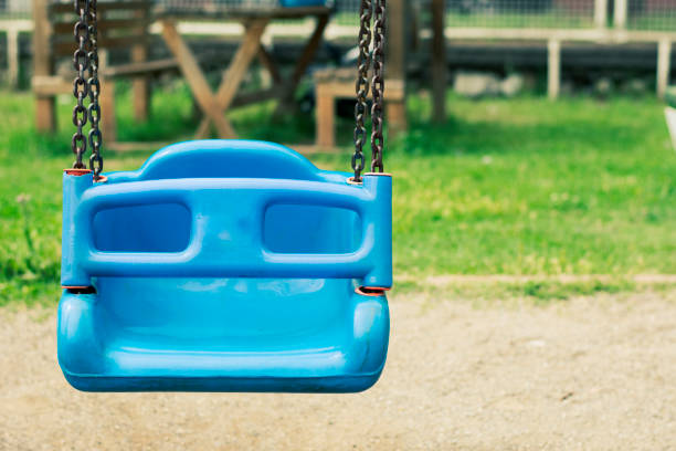 blue color swing in playground and green background