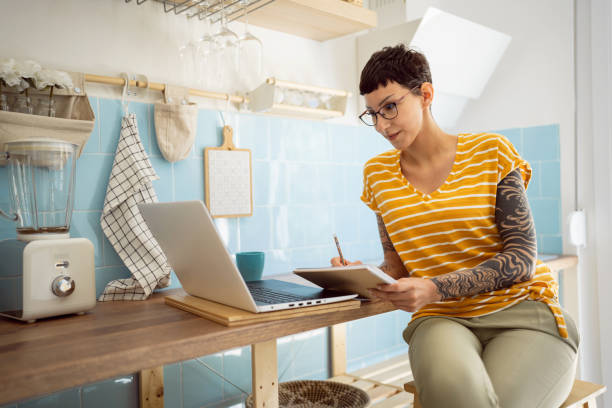 istock Young Caucasian woman working on laptop from kitchen 1399756719