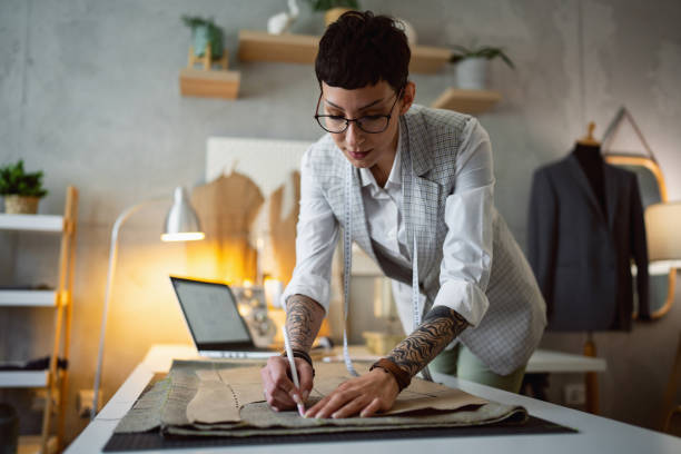 istock Caucasian female tailor outline the pattern on the textile 1399756756