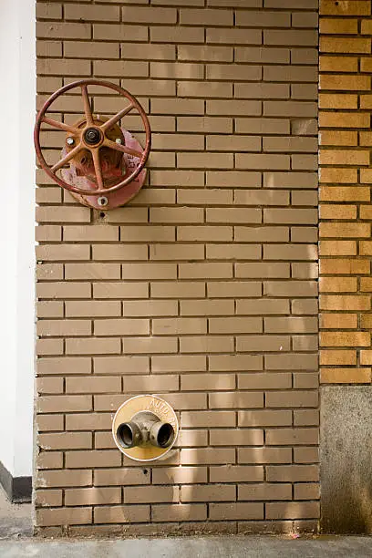 fire hydrant elements protruding from brick wall