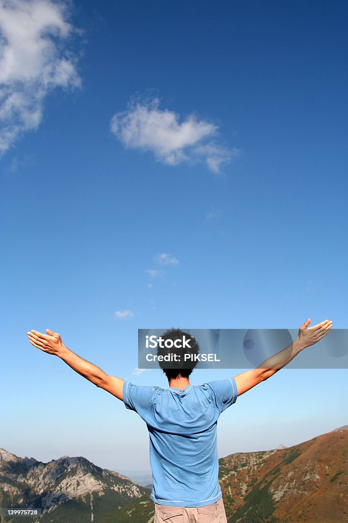 Uomo con le braccia tese in montagne - Foto stock royalty-free di Adulto
