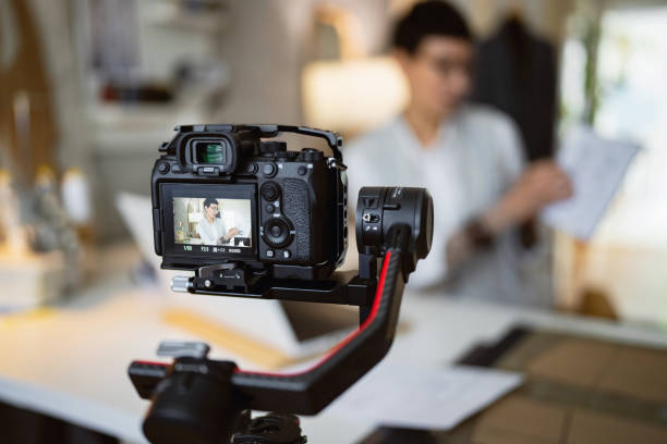 istock Female fashion designer and tailor, recording with her camera, tutorial or easy DIY from her design studio 1399757962