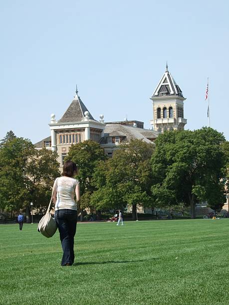 Off to class A student walks across the Quad at Utah State University on the way to Old Main for classes. utah state university stock pictures, royalty-free photos & images