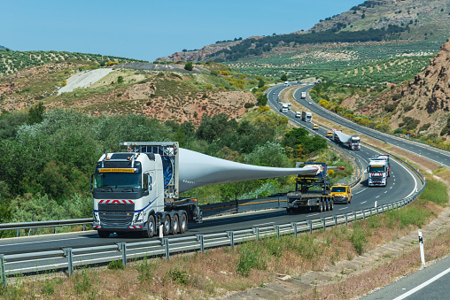 Convoy of trucks transporting wind turbine blades.