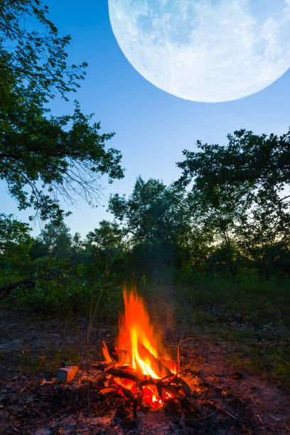 istock huge moon shining above campfire in forest , natural camping twilight background 1399762566