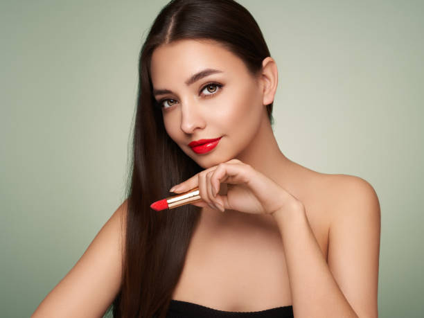 istock A beautiful young woman applying lipstick 1399763458