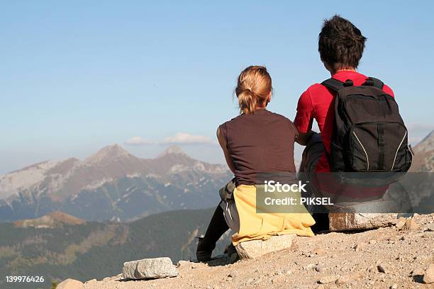 Couple Sitting And Looking Over Mountains Stock Photo - Download Image Now - Adult, Adults Only, Back
