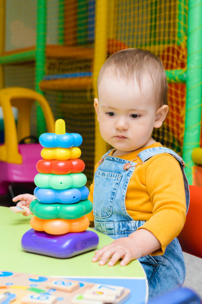istock A small child plays with an educational toy pyramid with rings 1399767033