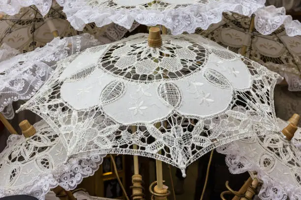 Photo of white umbrellas. Sun protection, hot weather concept. Traditional souvenirs in Burano island, Venice, Italy