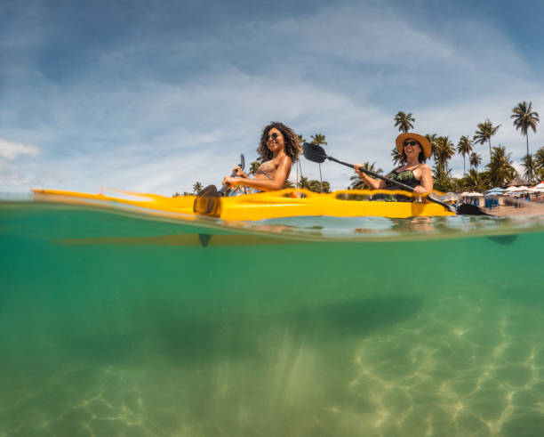 Tourists paddling kayak on the beach Tourists paddling kayak at Porto de Galinhas beach in Pernambuco, Brazil kayaking stock pictures, royalty-free photos & images