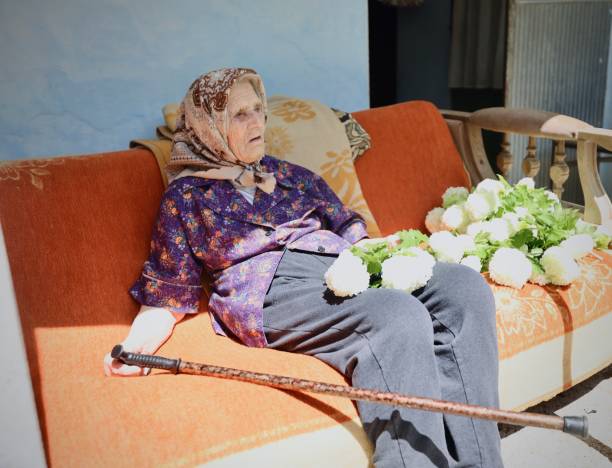 Granny sitting alone outside with flowers