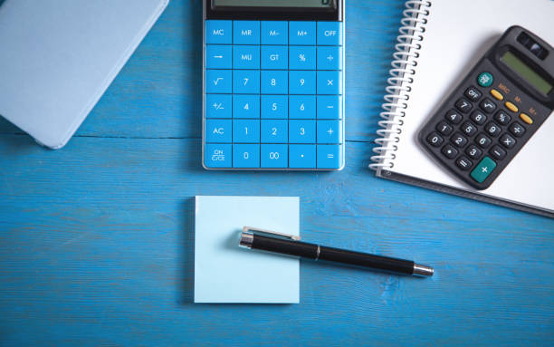 istock Pen, notepad and calculator on the blue background. 1399770130
