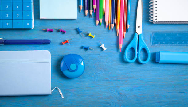 istock Calculator, pencils, note, eraser scissors, marker, sticky notes on the blue background. 1399770137