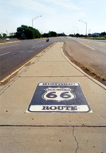 Route 66 in Tucumcari, New Mexico, on the West side of Town looking East. Historic New Mexico Route 66 emblem stenciled on concrete median.
