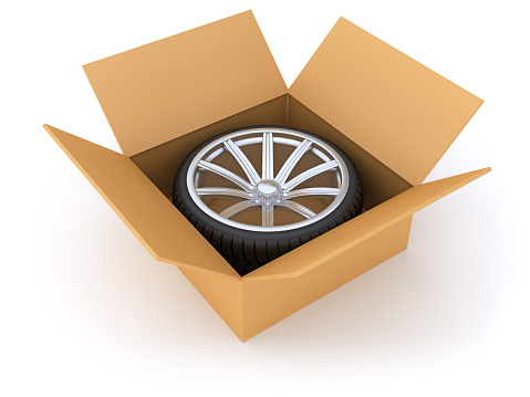 Car wheel in cardboard box. Digitally Generated Image isolated on white background