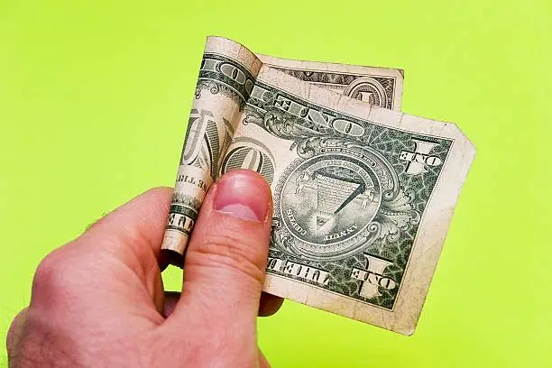 Man's hand offering one dollar bill on a green background