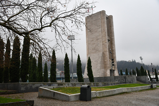 Como, Italy - December 19, 2019: The Monumento ai Caduti (Monument to the Fallen), a World War I memorial designed by architect Giuseppe Terragni and completed in 1933, on a foggy day.