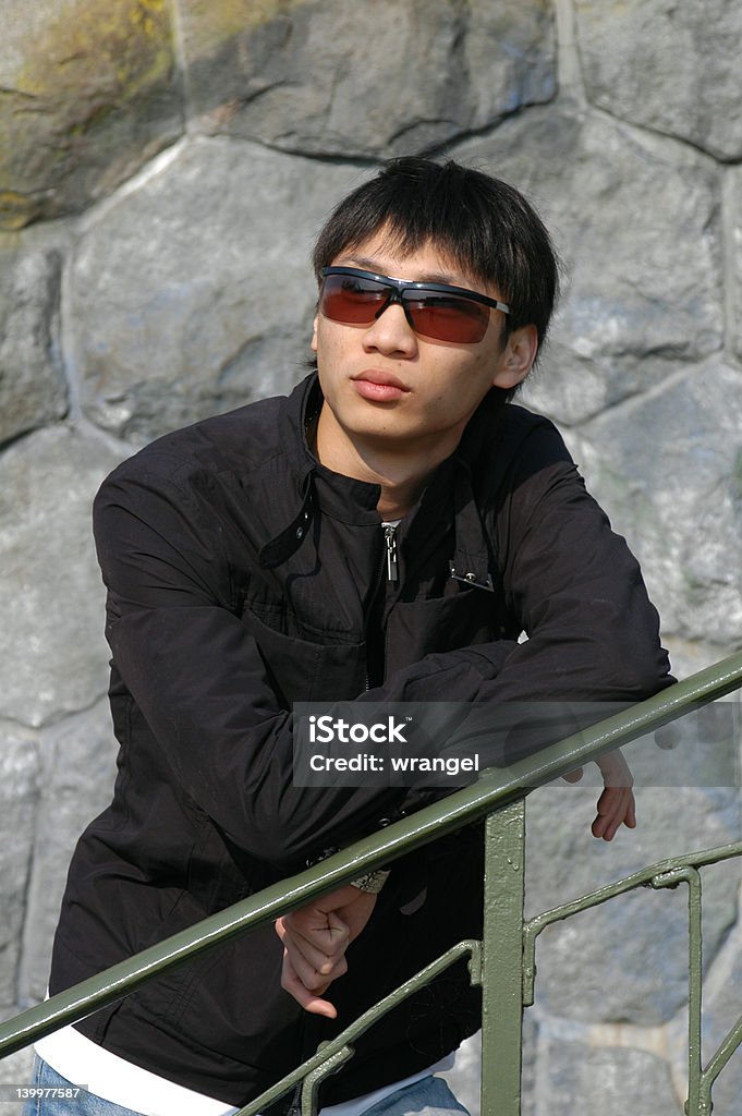 Asiatique homme s'appuyant sur une clôture - Photo de A la mode libre de droits