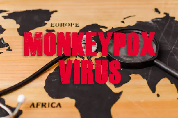 Photo of Monkeypox is caused by monkeypox virus.Smallpox is a viral zoonotic disease. Virus transmitted to humans from animals.inscription world wooden map,a stethoscope and a magnifying lip lie on the map.
