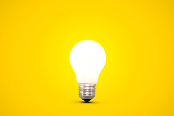 istock Glowing light bulb isolated on a bright yellow background. 1399778740