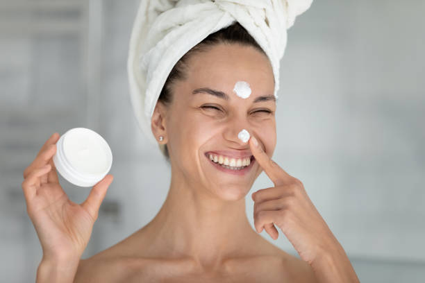 istock Joyful young hispanic woman applying moisturizing cream on face. 1399779296