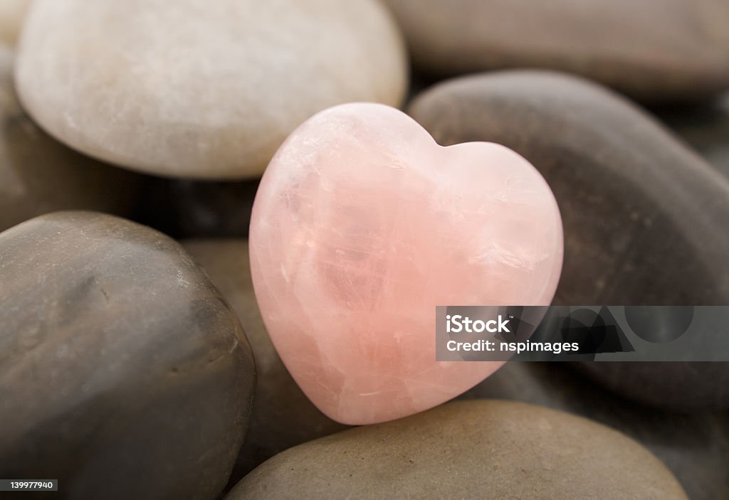 Rose quartz heart Rose quartz heart on pebbles Heart Shape Stock Photo