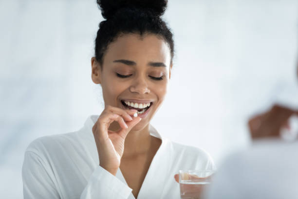 istock Pretty young african ethnicity woman taking dietary supplements. 1399779833