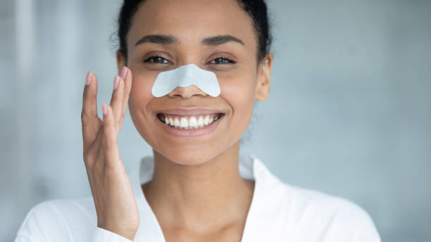 istock Happy beautiful african ethnicity woman using nose cleansing strip. 1399779869