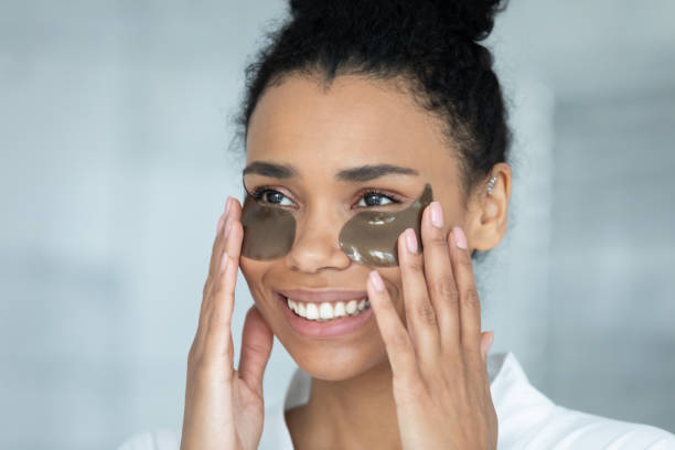 Happy young african american woman applying patches.